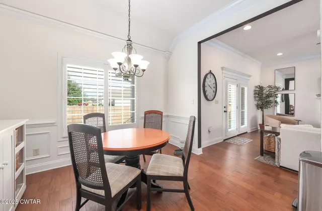 a dining room with furniture a chandelier and wooden floor