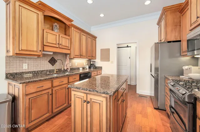 a kitchen with stainless steel appliances granite countertop a stove a sink dishwasher and a refrigerator