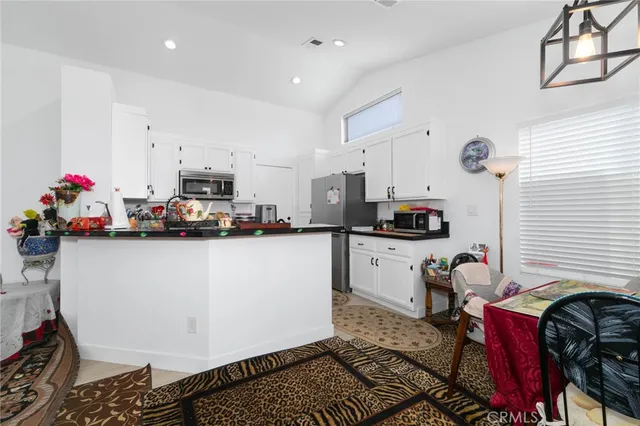a kitchen view with kitchen island stainless steel appliances a sink a stove a chimney and cabinets