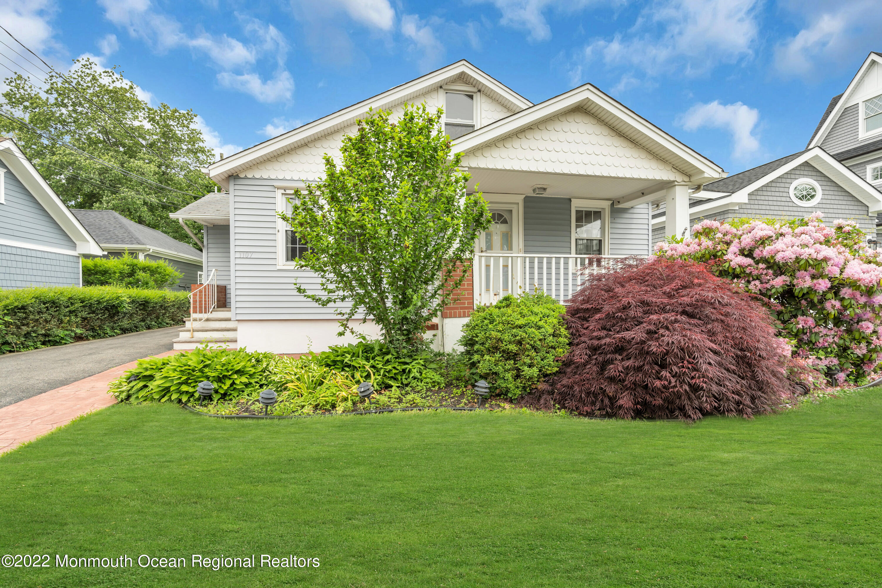 1107 5th Avenue Spring Lake, NJ 07762 - Photo 2 of 30 a front view of a house with a garden