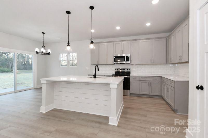 269 Monticello Road Statesville, NC 28625 - Photo 7 of 31 a kitchen with kitchen island granite countertop a sink a counter space appliances and cabinets