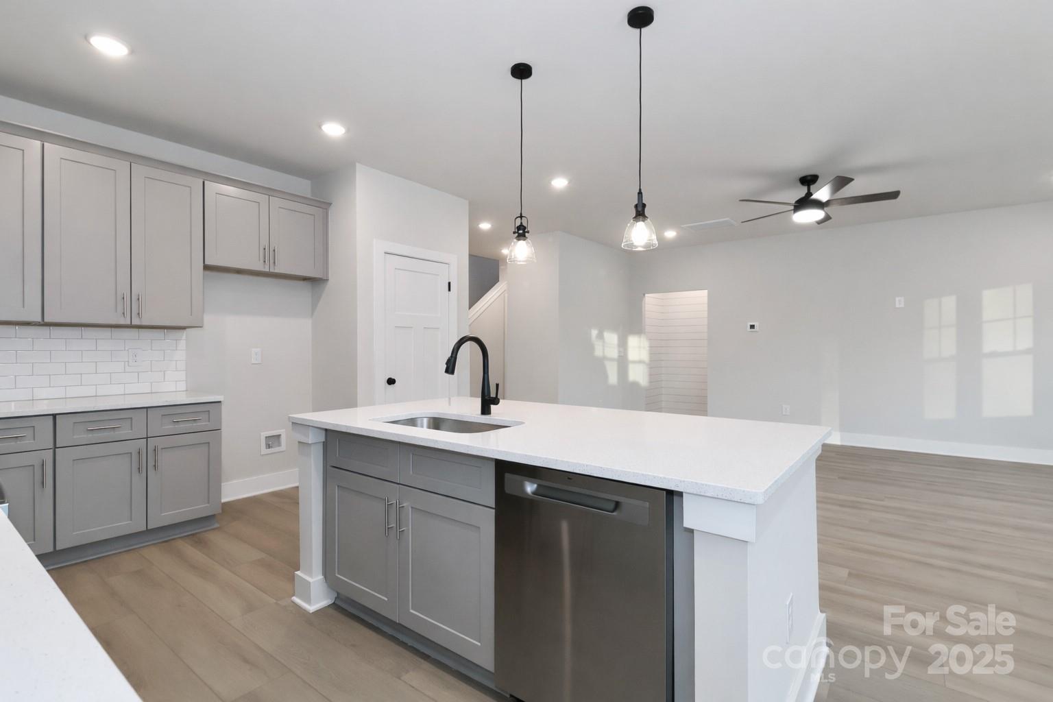 269 Monticello Road Statesville, NC 28625 - Photo 10 of 31 a kitchen with a sink dishwasher and white cabinets with wooden floor