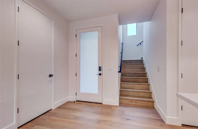 a view of a hallway with wooden floor and entryway