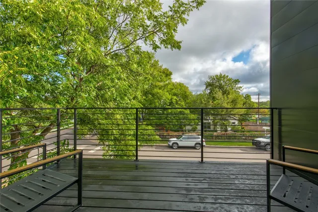 a view of a balcony with wooden floor and bench