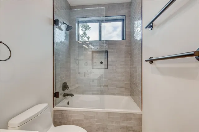 a bathroom with a tub shower and toilet