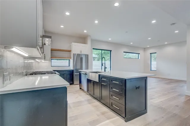 a kitchen with kitchen island granite countertop a sink counter top space and stainless steel appliances