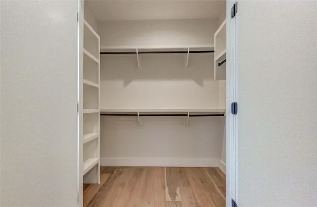 a view of walk in closet with empty racks