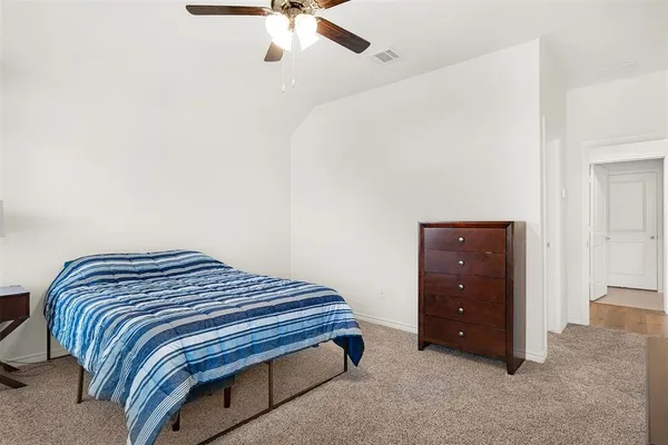 a bedroom with a bed and a ceiling fan