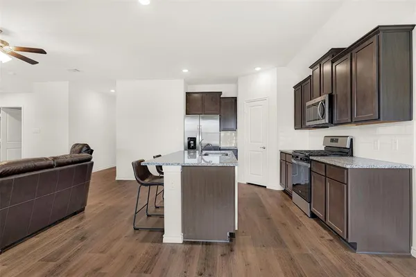 a large kitchen with stainless steel appliances wooden floors and wooden cabinets
