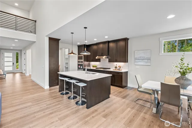 a kitchen with a wooden floor and chairs
