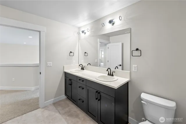 a bathroom with a double vanity sink toilet mirror and shower
