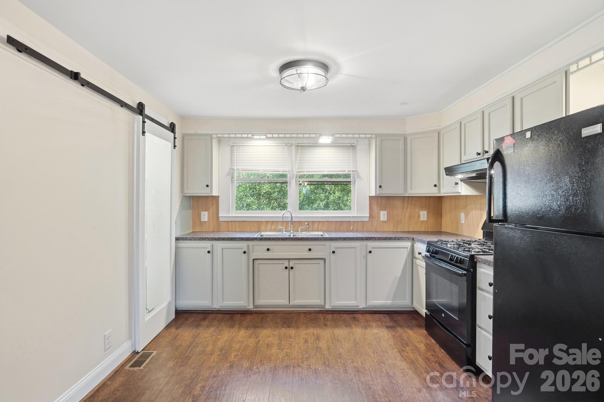 149 Swink Street Southwest Concord, NC 28027 - Photo 13 of 24 a kitchen with a sink a window and stainless steel appliances