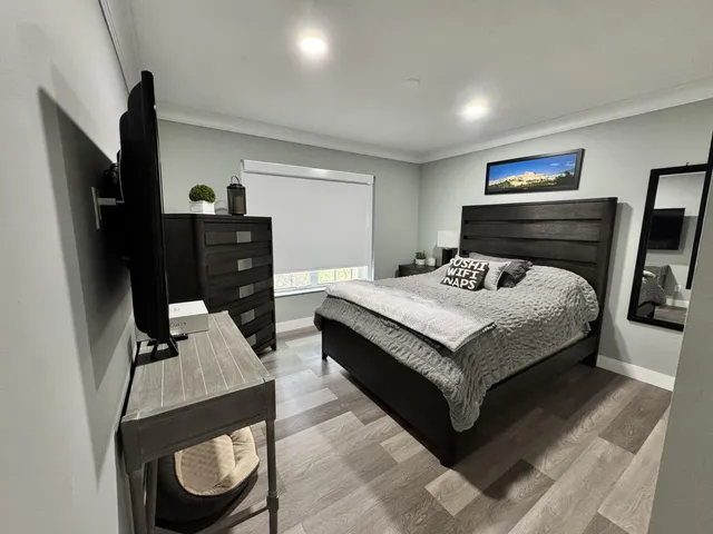 a bedroom with a bed and wooden floor