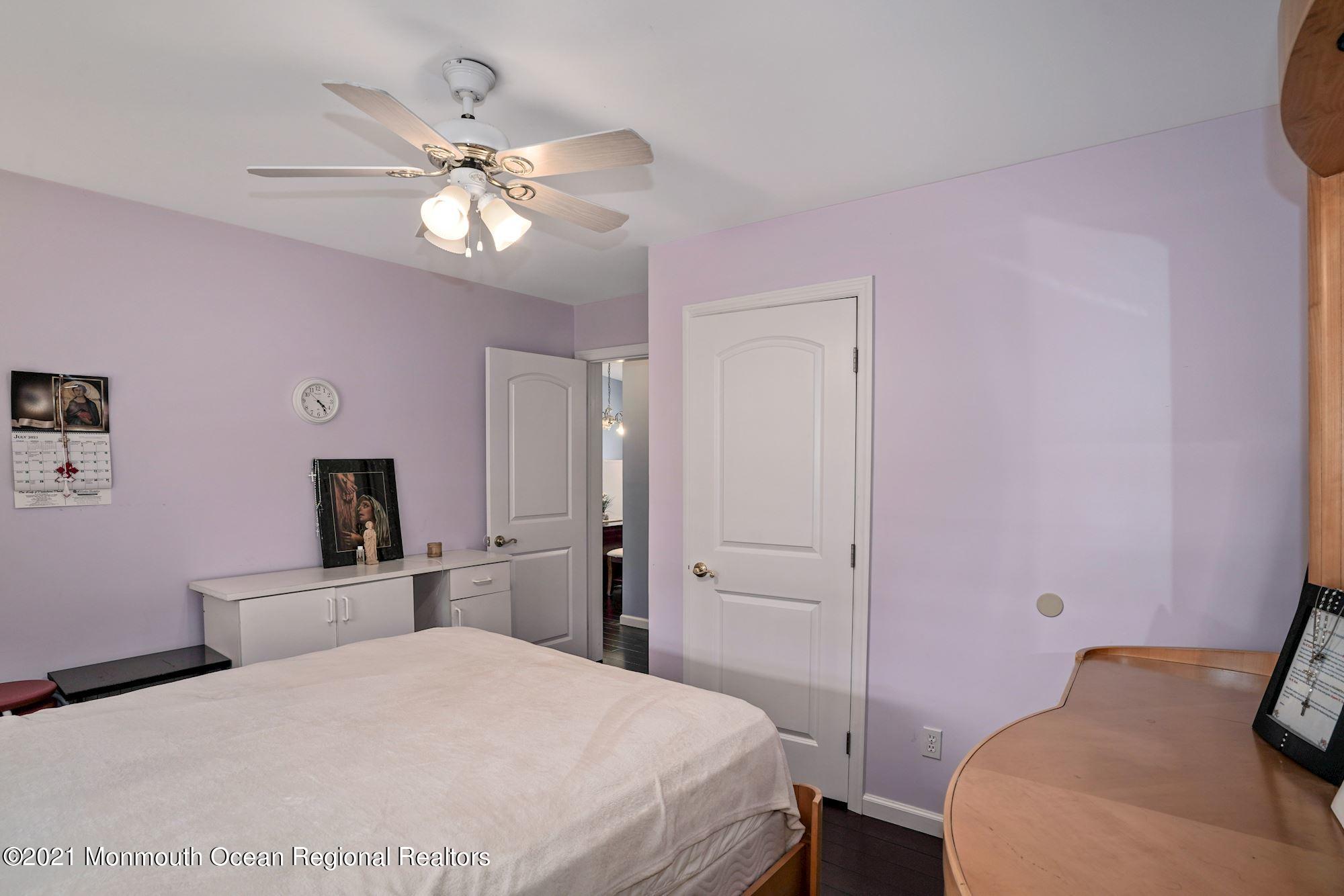 657 Drum Point Road Brick, NJ 08723 - Photo 12 of 25 a bedroom with a bed and a chandelier