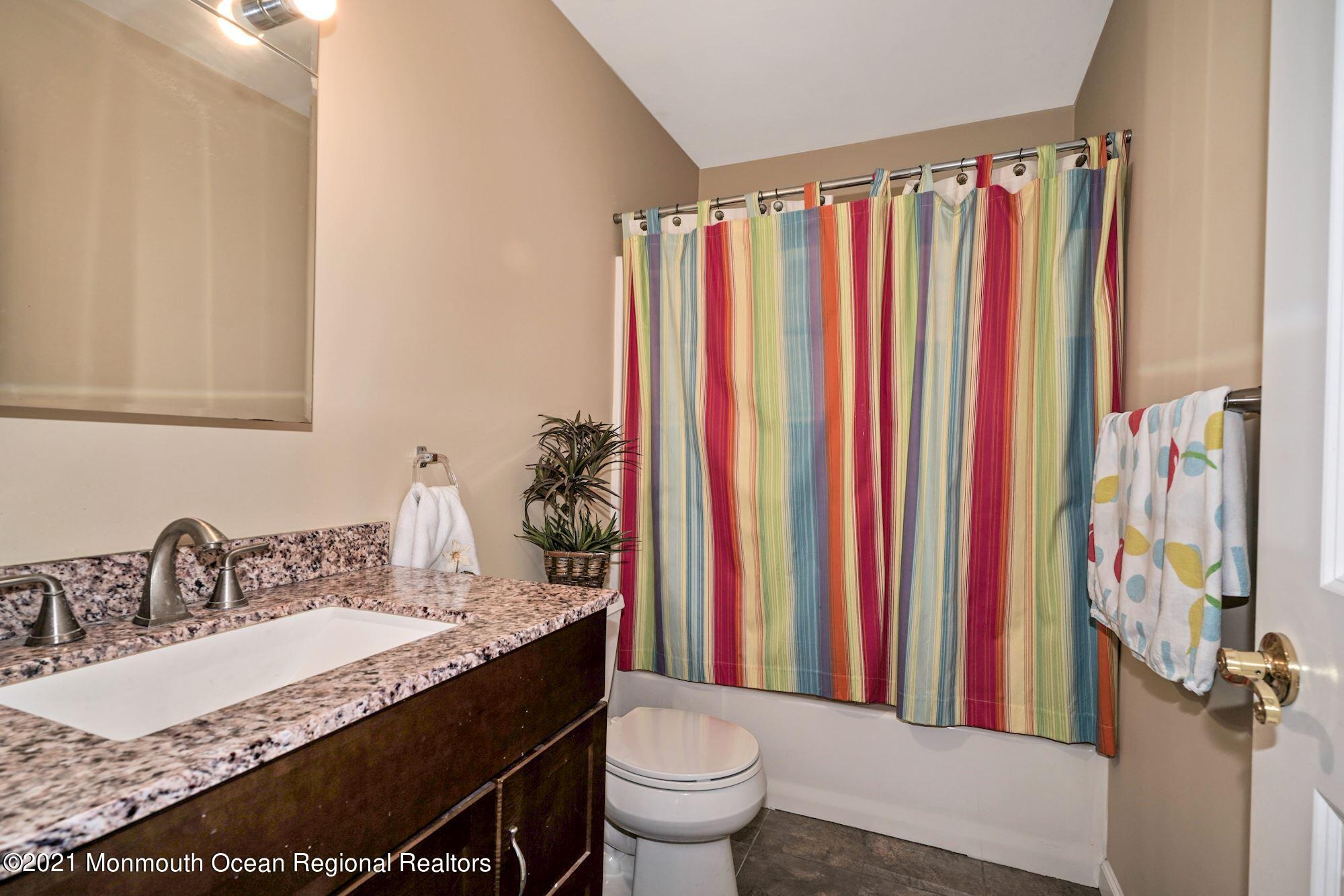 657 Drum Point Road Brick, NJ 08723 - Photo 13 of 25 a bathroom with a granite countertop sink and a mirror