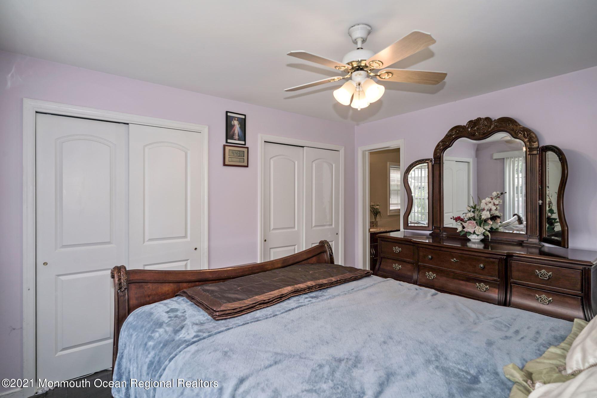 657 Drum Point Road Brick, NJ 08723 - Photo 17 of 25 a bedroom with a bed and a chandelier