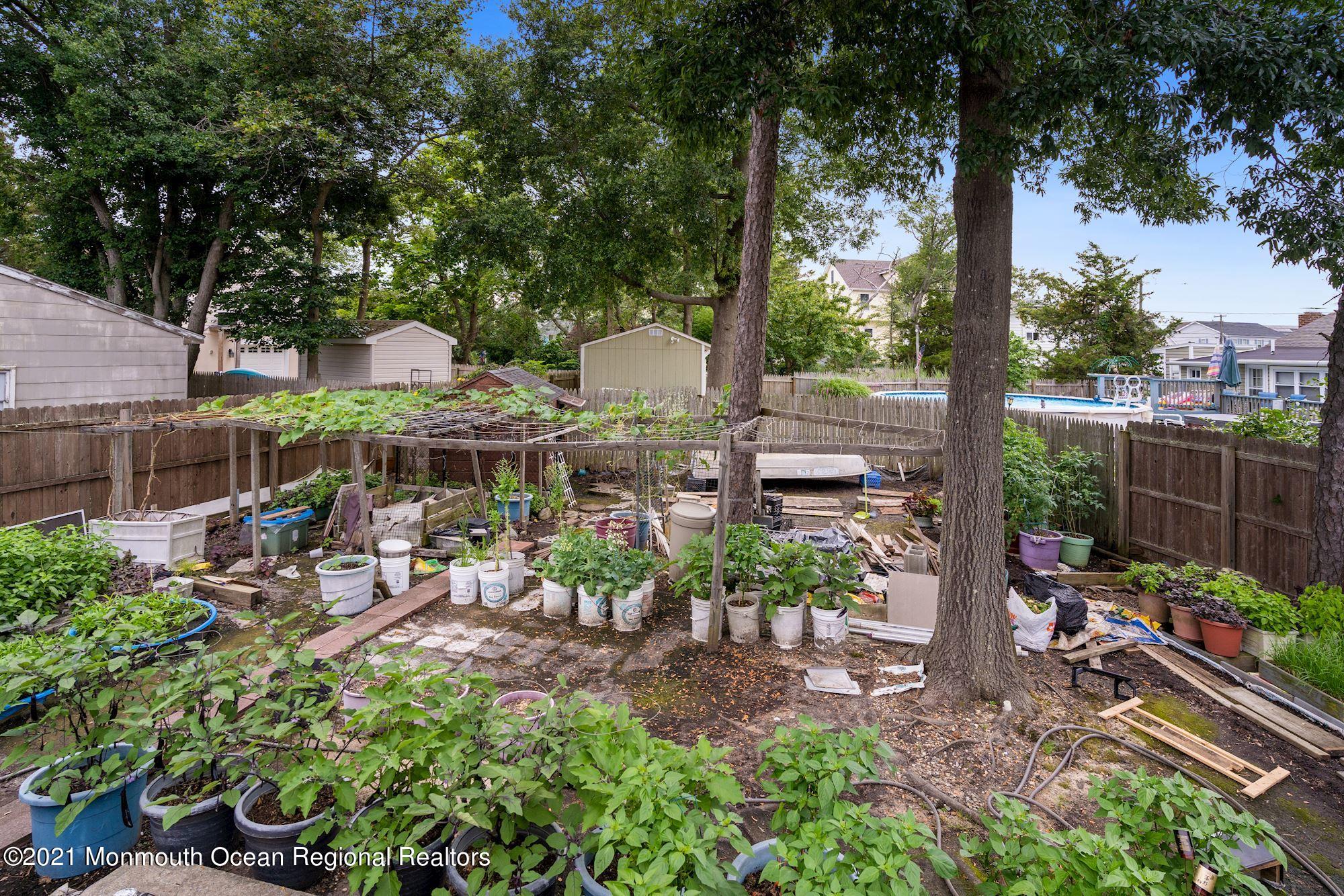 657 Drum Point Road Brick, NJ 08723 - Photo 19 of 25 a view of a patio with table and chairs potted plants and large tree