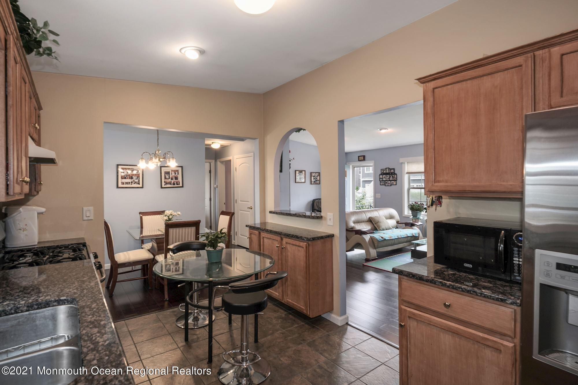 657 Drum Point Road Brick, NJ 08723 - Photo 3 of 25 a kitchen with stainless steel appliances a dining table and chairs