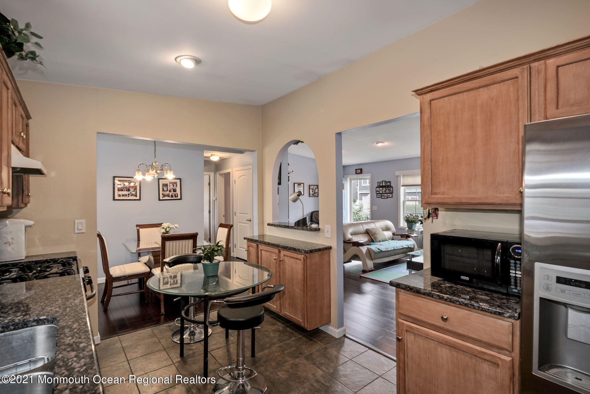 657 Drum Point Road Brick, NJ 08723 - Photo 4 of 25 a kitchen with a table chairs refrigerator and cabinets