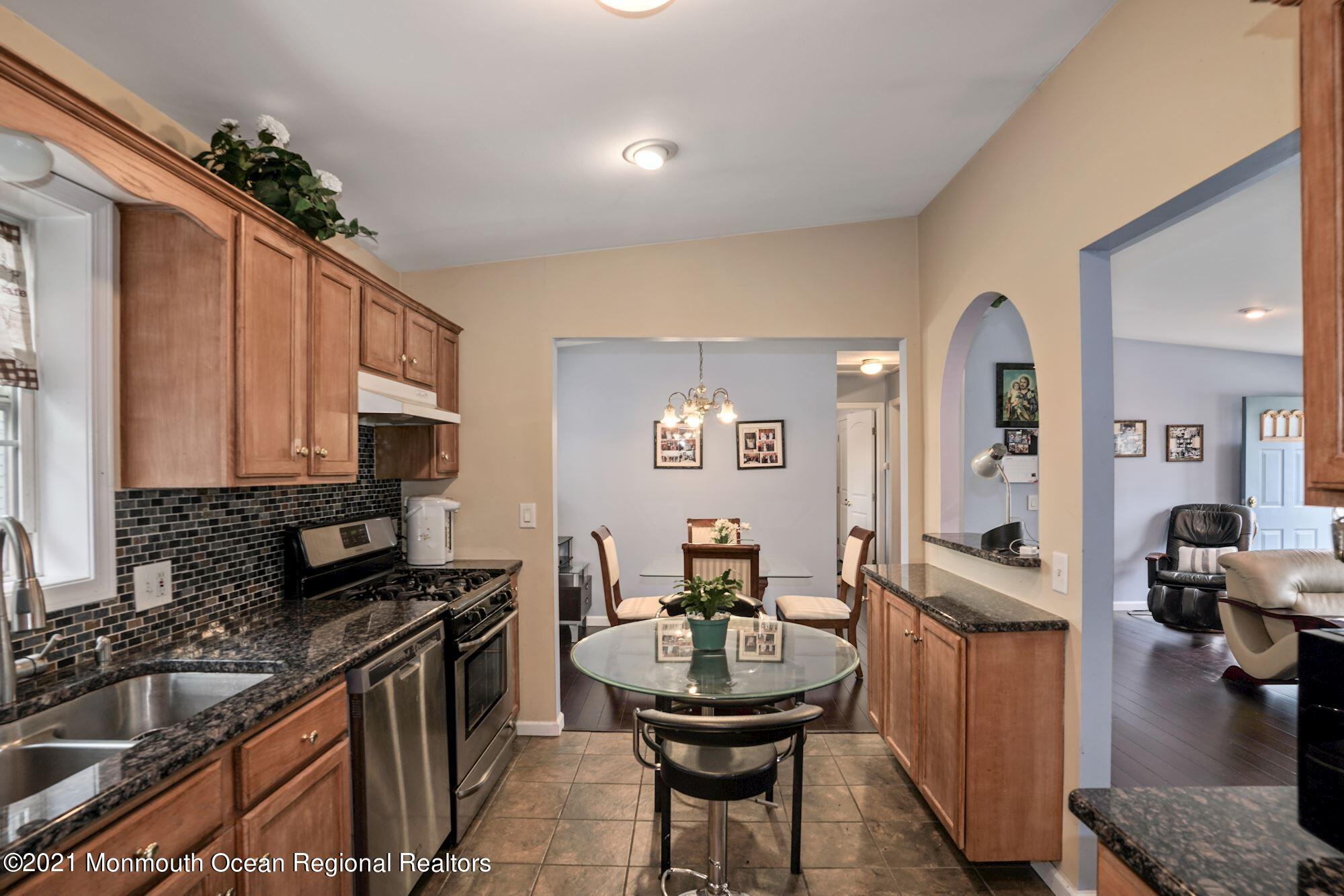 657 Drum Point Road Brick, NJ 08723 - Photo 5 of 25 a kitchen with sink refrigerator and cabinets