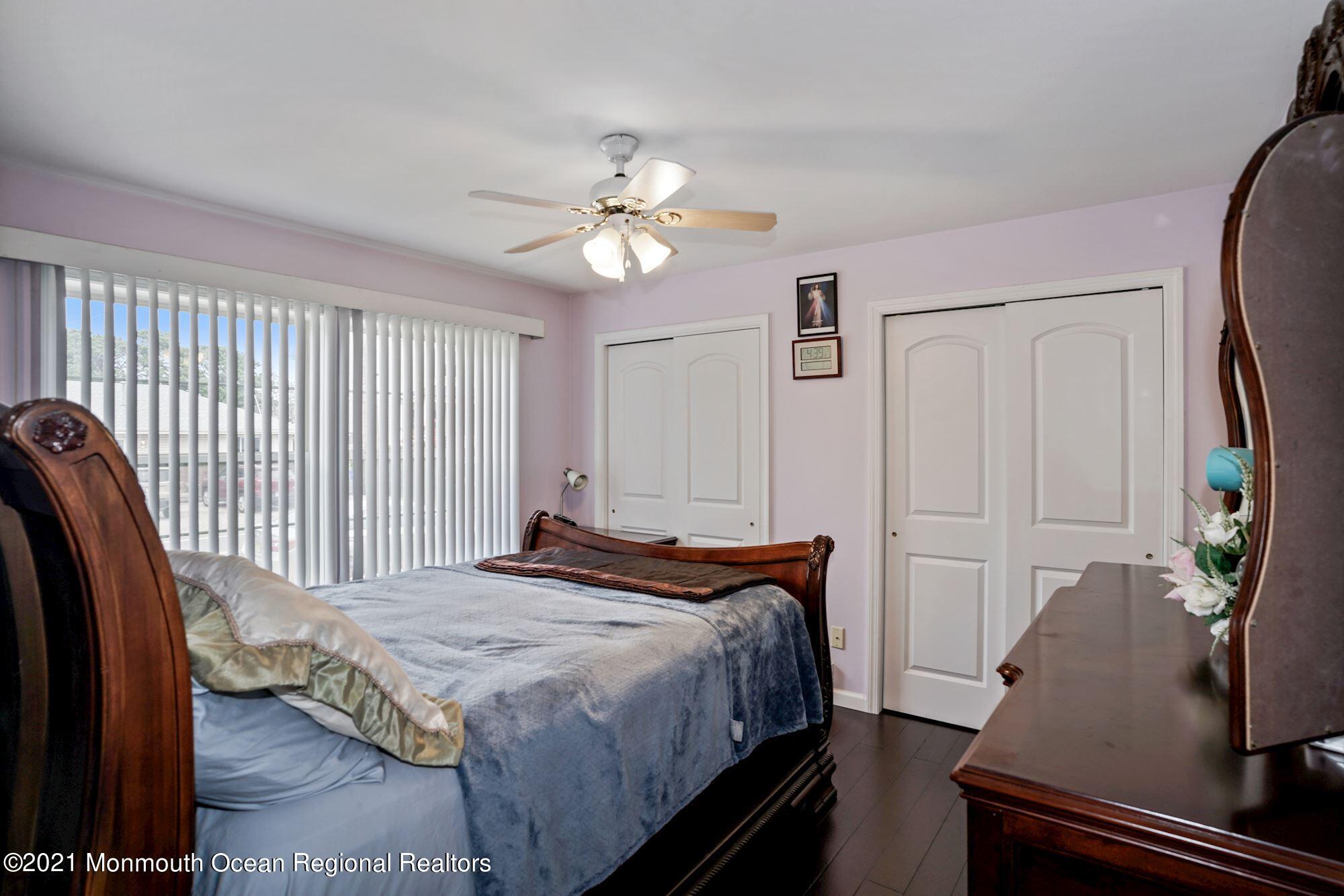 657 Drum Point Road Brick, NJ 08723 - Photo 8 of 25 a bedroom with a bed and a chandelier