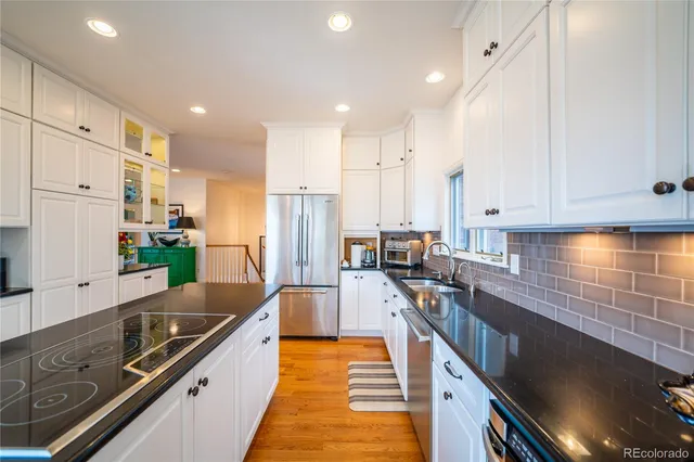 a kitchen with stainless steel appliances a stove a sink a microwave a refrigerator and cabinets