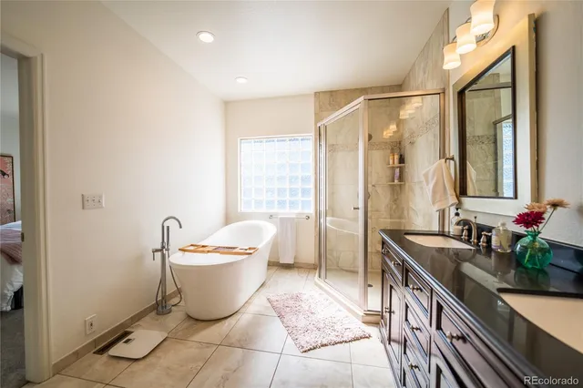 a spacious bathroom with a double vanity sink mirror and a bathtub