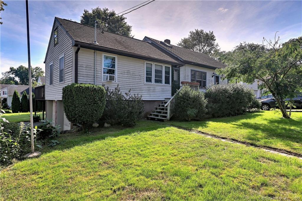 a view of a house with backyard and sitting area