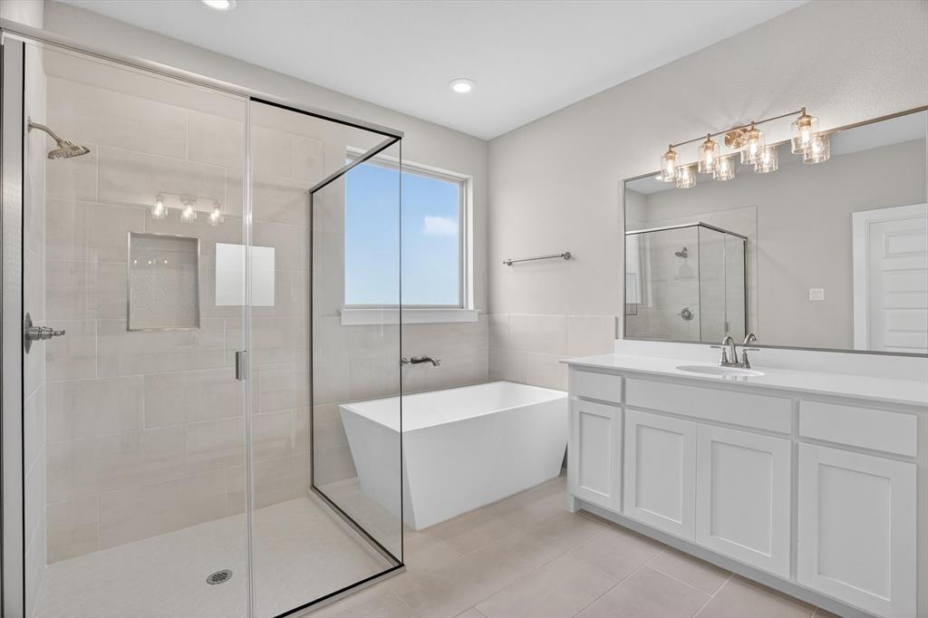 504 Clifton Court Springtown, TX 76082 - Photo 31 of 36 Contemporary bathroom featuring a frameless glass shower enclosure, a freestanding soaking tub, a double vanity with white cabinetry, a large wall-mounted mirror, and tile flooring