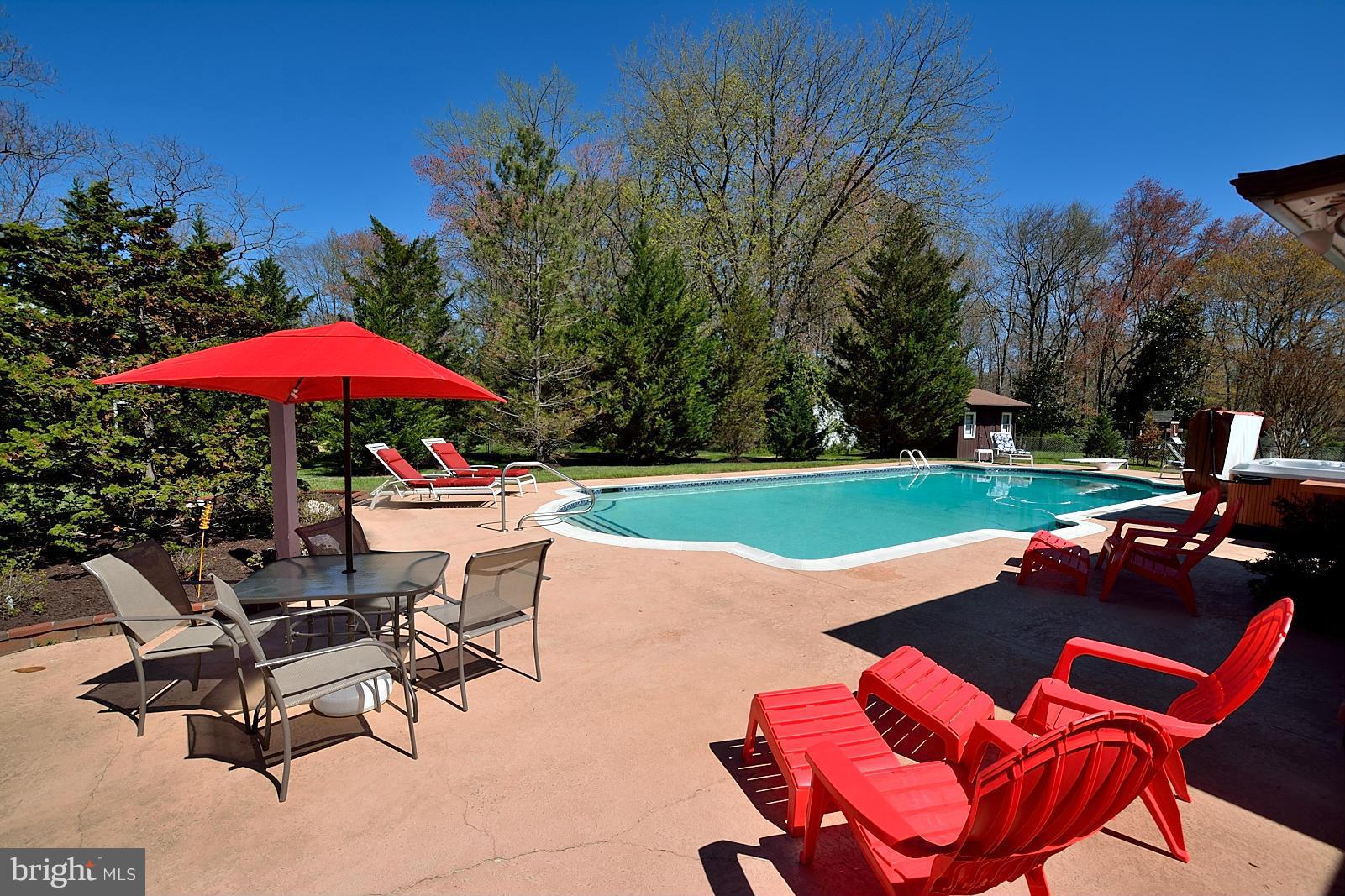 4902 Pole Road Alexandria, VA 22309 - Photo 21 of 30 a view of a swimming pool with lawn chairs under an umbrella