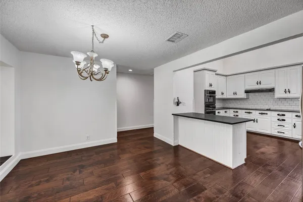 a kitchen with stainless steel appliances granite countertop a sink a stove a refrigerator cabinets and wooden floor