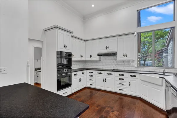 a kitchen with granite countertop white cabinets and stainless steel appliances
