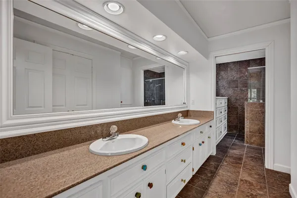 a bathroom with a granite countertop double vanity sink and mirror