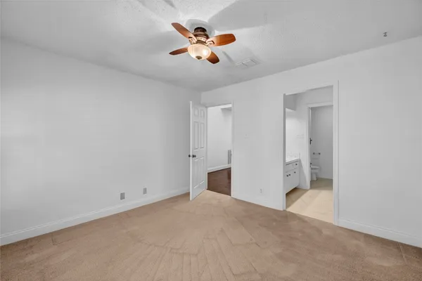 an empty room with closet and fan