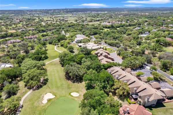 an aerial view of residential houses with outdoor space and trees