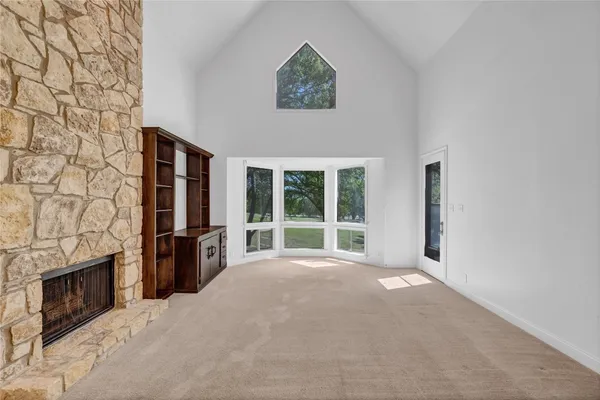 a view of an empty room with a fireplace and a window
