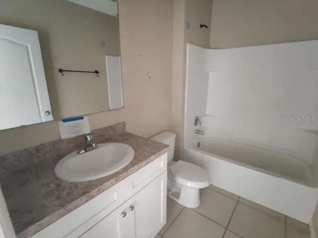 a bathroom with a granite countertop sink a toilet and shower