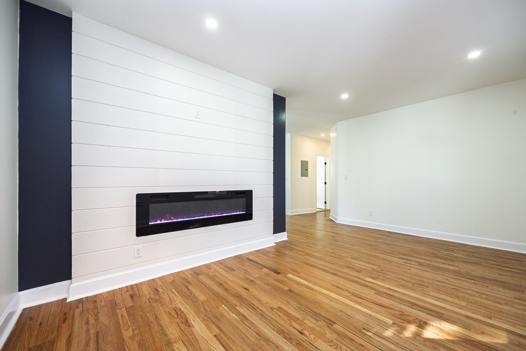 40 Devon Street, Unit 1 Boston, MA 02121 - Photo 6 of 35 a view of empty room with wooden floor and fireplace