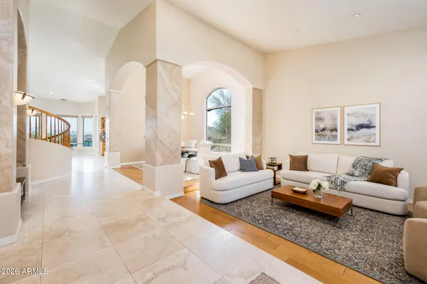 a view of a hallway with wooden floor and windows with a bathroom