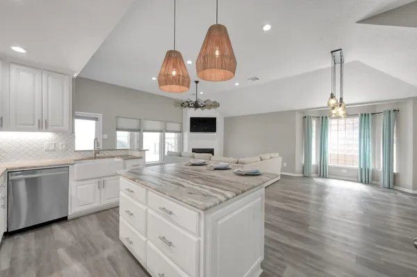 a kitchen with stainless steel appliances granite countertop a refrigerator a oven and a sink with wooden floor