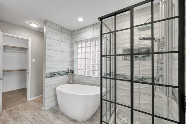 a spacious bathroom with a granite countertop sink a mirror and a shower