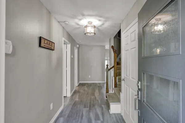a view of a hallway with wooden floor and staircase
