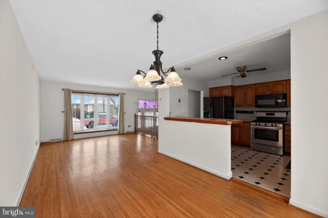 a view of a living room and kitchen with furniture wooden floor