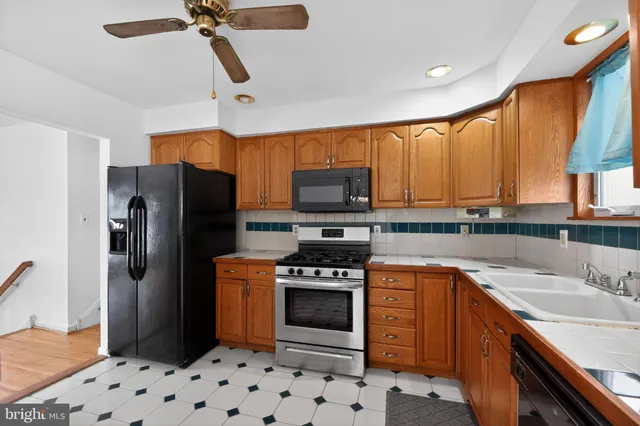 a kitchen with stainless steel appliances a stove a sink and a refrigerator