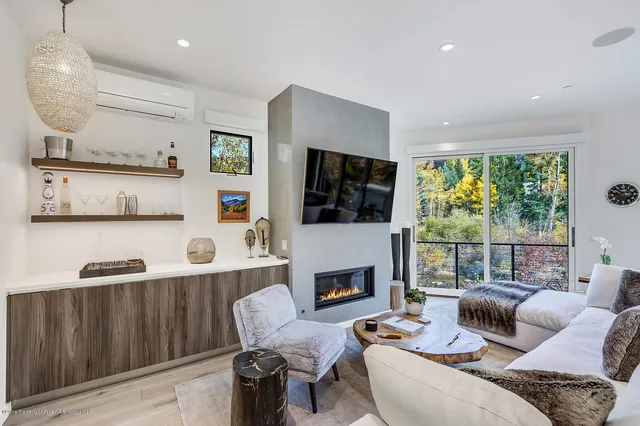 a living room with furniture fireplace and a large window