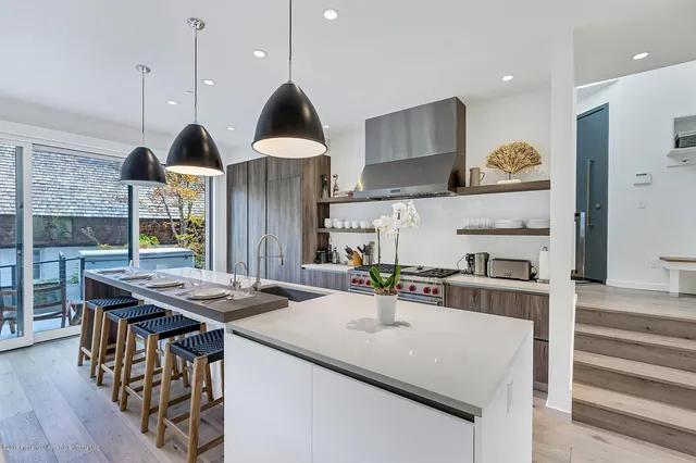 a kitchen with stainless steel appliances granite countertop a sink a stove and a wooden floors