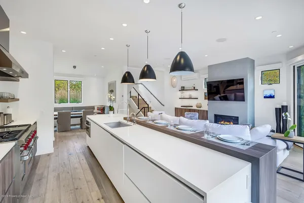 a kitchen with stainless steel appliances granite countertop a sink a stove and a wooden floors