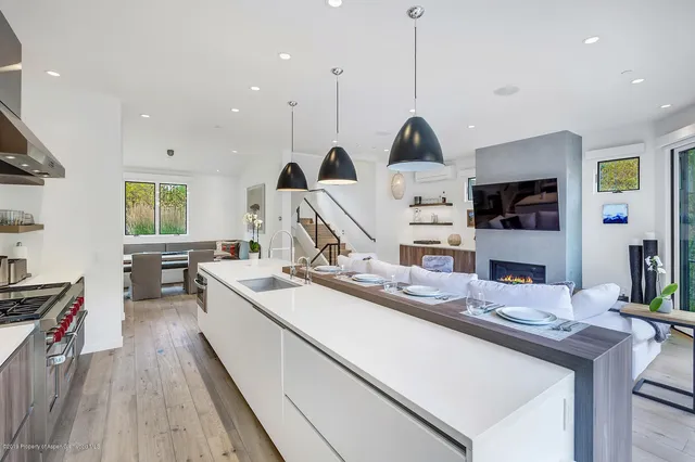 a kitchen with stainless steel appliances granite countertop a sink a stove and a wooden floors