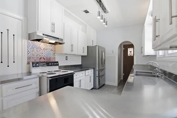 a kitchen with a sink stove and refrigerator