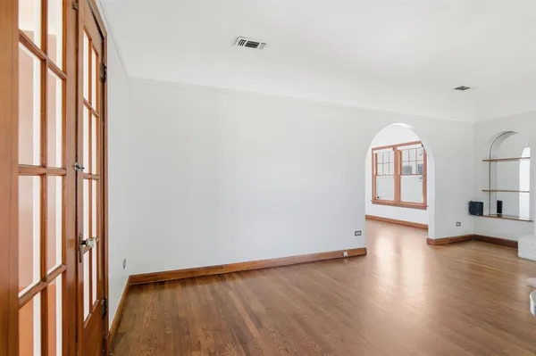 a view of empty room with wooden floor and fireplace